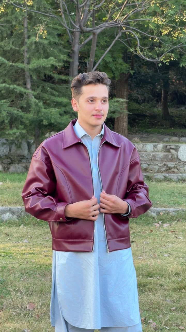 Burgundy leather jacket worn outdoors among trees